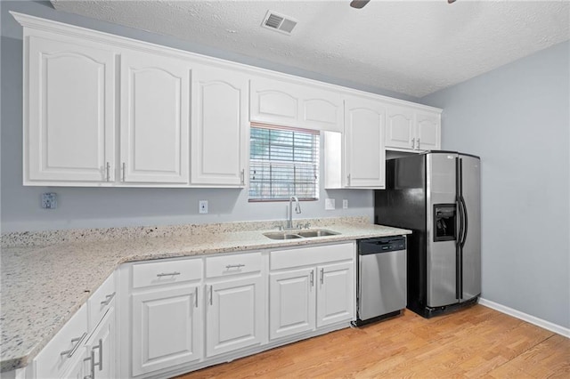 kitchen with visible vents, appliances with stainless steel finishes, light wood-type flooring, white cabinetry, and a sink