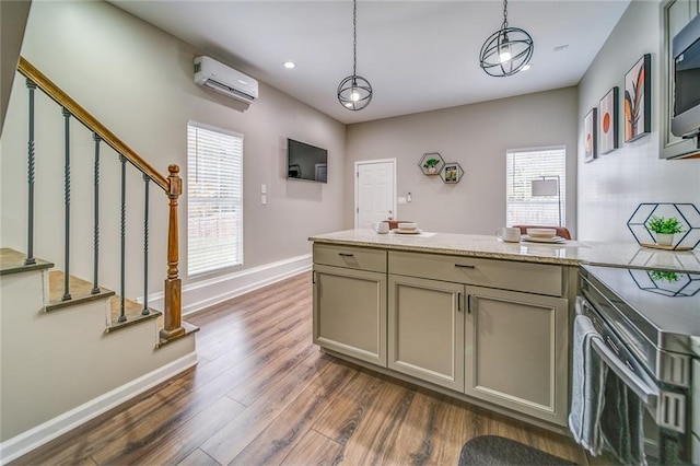 kitchen with a peninsula, baseboards, dark wood-style floors, a wall mounted air conditioner, and pendant lighting