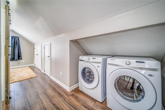 washroom with baseboards, laundry area, wood finished floors, and washer and dryer