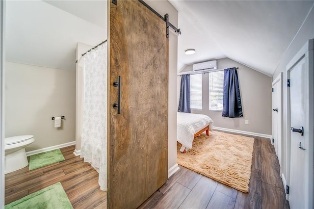 bathroom featuring lofted ceiling, connected bathroom, toilet, wood finished floors, and baseboards