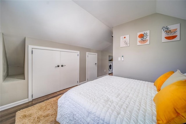 bedroom featuring multiple closets, vaulted ceiling, and wood finished floors