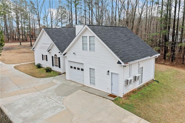 view of front facade with a garage, concrete driveway, a chimney, roof with shingles, and a front yard