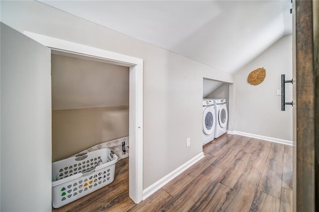 clothes washing area with washing machine and dryer, laundry area, baseboards, and wood finished floors