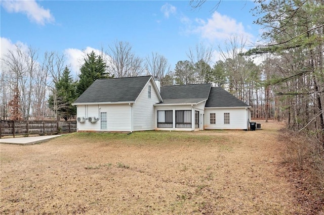 rear view of house featuring a yard, a sunroom, and fence