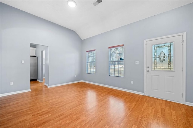 foyer featuring light wood-style floors, lofted ceiling, and baseboards