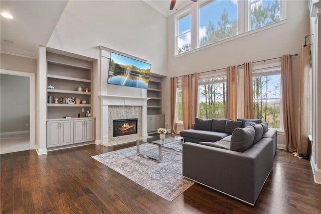 4402 Income Cir, Ellenwood, GA 30294 - living room featuring crown molding, a fireplace with flush hearth, ceiling fan, baseboards, and built in features