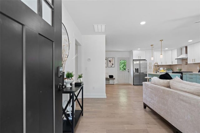 living room featuring light wood-style flooring, recessed lighting, and baseboards