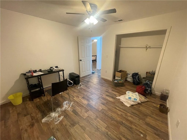 bedroom featuring dark hardwood / wood-style floors, ceiling fan, and a closet