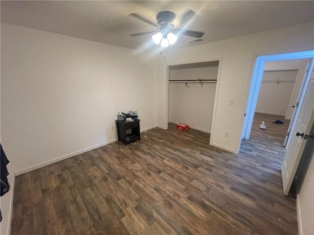 unfurnished bedroom with ceiling fan, a closet, and dark wood-type flooring