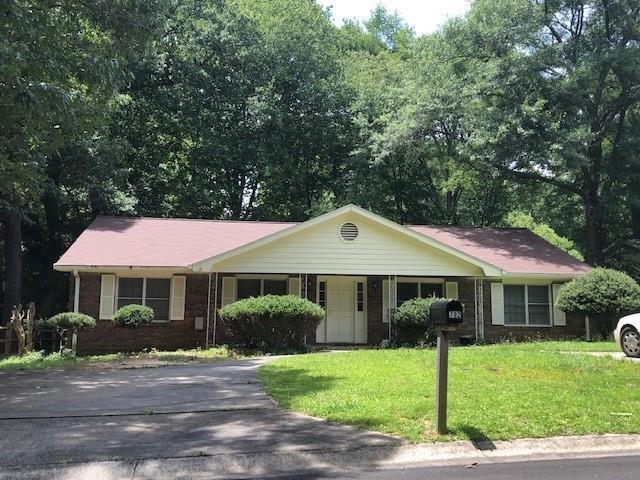 ranch-style home with a front lawn and driveway