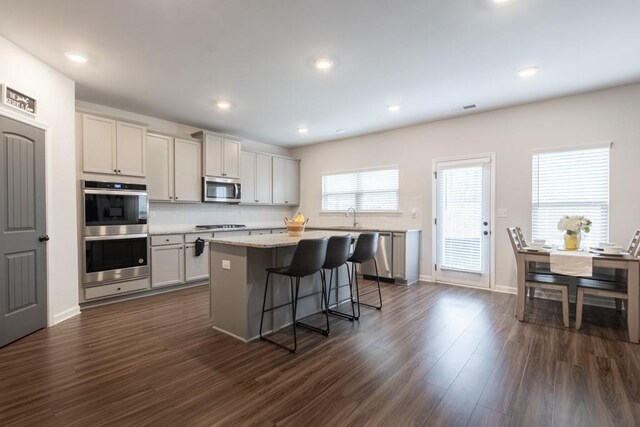 4824 Sultana Way SW, Atlanta, GA 30331 - kitchen featuring a kitchen island, a breakfast bar area, dark wood-style floors, stainless steel appliances, and visible vents
