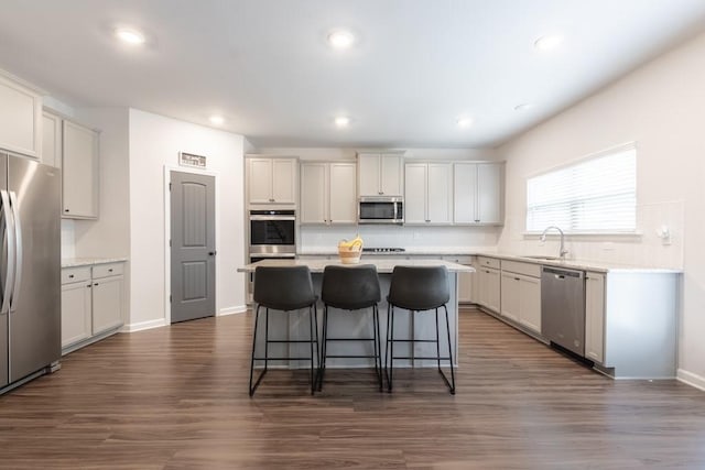 4824 Sultana Way SW, Atlanta, GA 30331 - kitchen featuring dark wood-style flooring, a center island, a breakfast bar, a sink, and appliances with stainless steel finishes