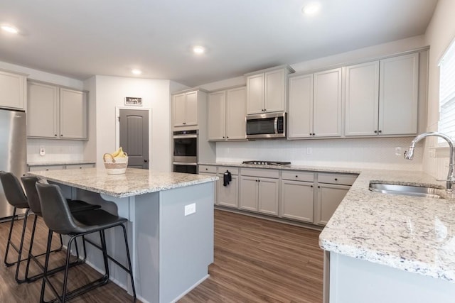 4824 Sultana Way SW, Atlanta, GA 30331 - kitchen featuring dark wood-style flooring, stainless steel appliances, a center island, a breakfast bar, and a sink