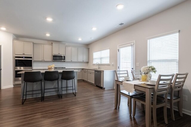 4824 Sultana Way SW, Atlanta, GA 30331 - kitchen with dark wood-style flooring, light countertops, visible vents, appliances with stainless steel finishes, and a center island
