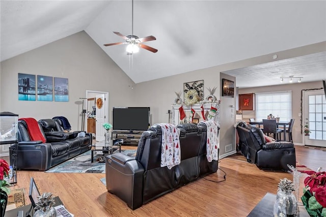 living room featuring wood-type flooring, vaulted ceiling, and ceiling fan