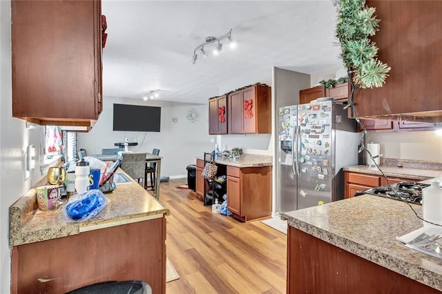 kitchen featuring stainless steel fridge and light hardwood / wood-style floors