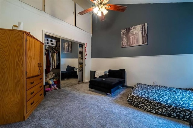 carpeted bedroom with a closet, high vaulted ceiling, and ceiling fan