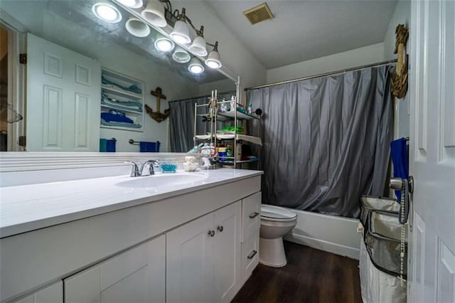 bathroom with visible vents, shower / bath combo with shower curtain, toilet, wood finished floors, and vanity