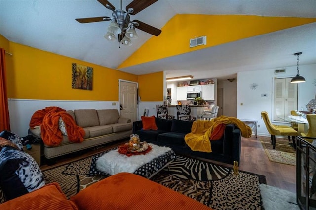 living area featuring visible vents, high vaulted ceiling, a ceiling fan, and wood finished floors