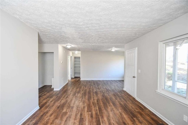 unfurnished room featuring dark hardwood / wood-style floors and a textured ceiling