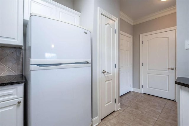 2304 Village Blvd, Rome, GA 30161 - kitchen featuring freestanding refrigerator, crown molding, white cabinetry, dark countertops, and light tile patterned flooring