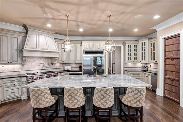 kitchen featuring dark hardwood / wood-style floors, premium appliances, custom exhaust hood, and dark stone counters