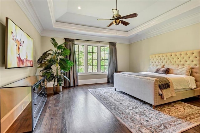 bedroom featuring ceiling fan, dark wood-type flooring, ornamental molding, and a tray ceiling