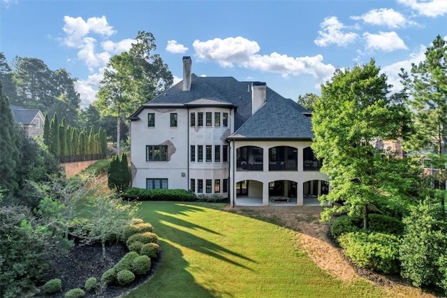 back of house featuring a patio area and a lawn