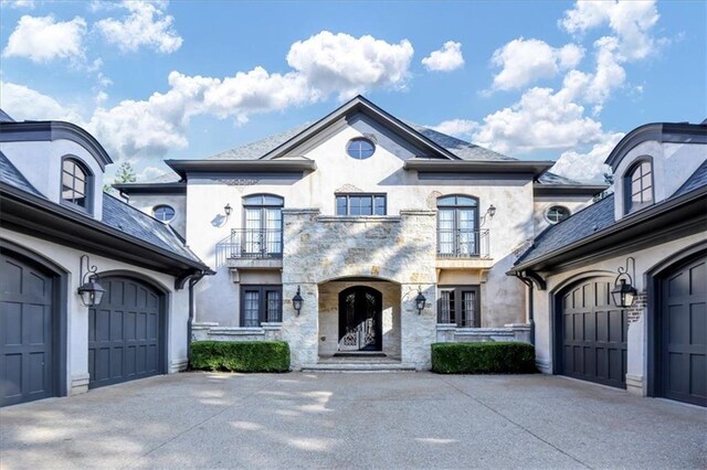 french provincial home featuring a balcony