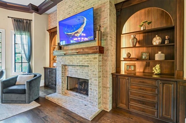 interior space featuring brick wall, dark wood-type flooring, and a brick fireplace