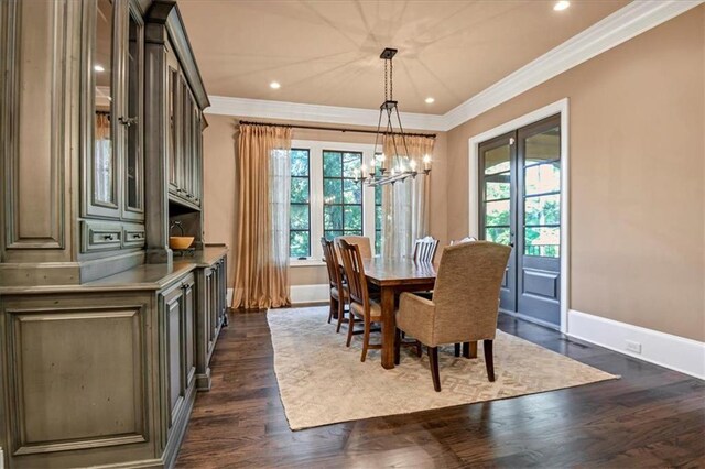 dining space featuring a wealth of natural light, crown molding, dark wood-type flooring, and a chandelier