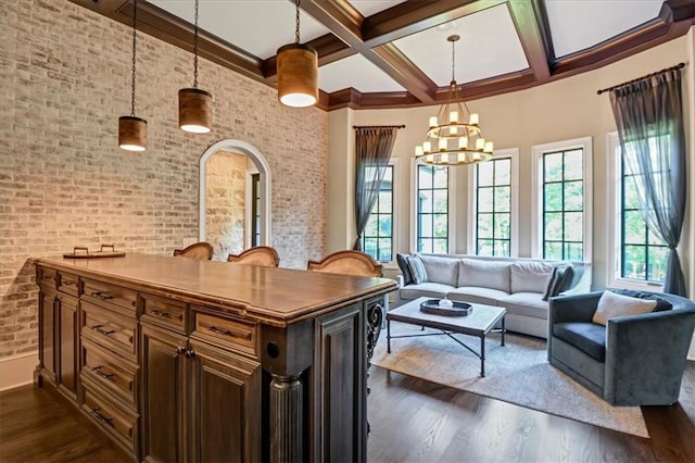 living room featuring dark hardwood / wood-style flooring, coffered ceiling, a chandelier, and brick wall