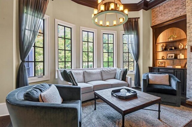 interior space with plenty of natural light, built in features, an inviting chandelier, and wood-type flooring