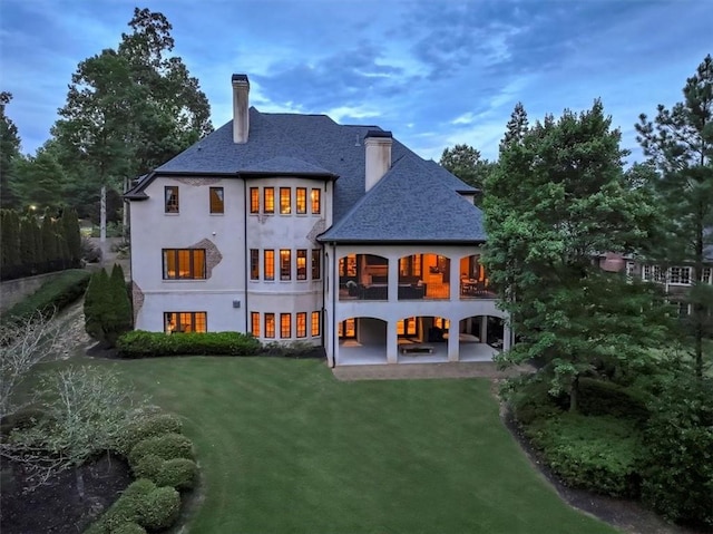 back of property with a patio area and a lawn