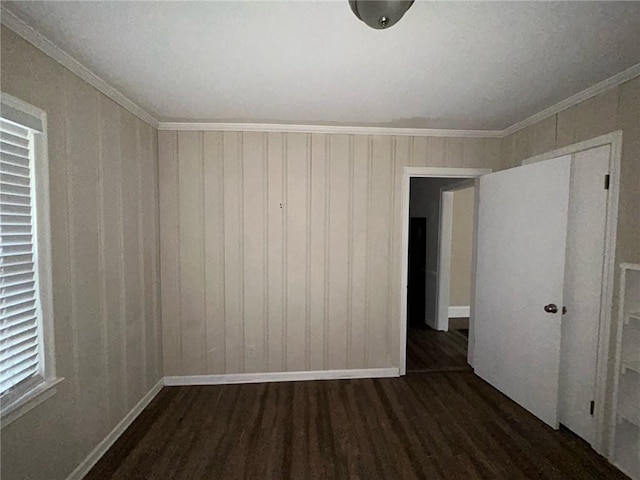 empty room featuring dark hardwood / wood-style flooring and ornamental molding