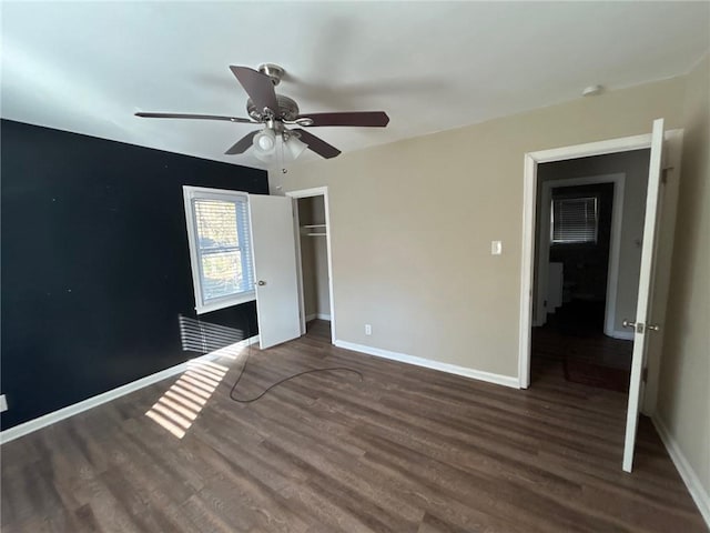 unfurnished bedroom featuring ceiling fan, a closet, and dark wood-type flooring