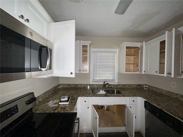 kitchen featuring electric stove, sink, white cabinets, and dark stone counters