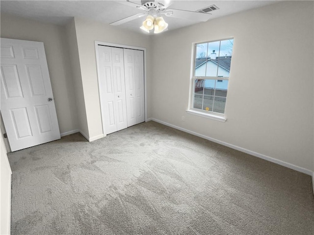 unfurnished bedroom with light carpet, baseboards, visible vents, a ceiling fan, and a closet