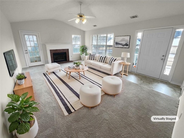 living area with carpet floors, visible vents, a ceiling fan, vaulted ceiling, and a brick fireplace