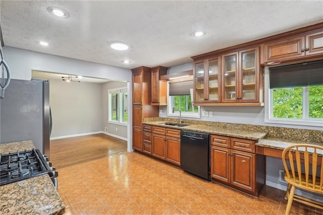 2201 Colonial Oak Way, Stone Mountain, GA 30087 - kitchen featuring black appliances, a sink, brown cabinetry, a textured ceiling, and light stone counters