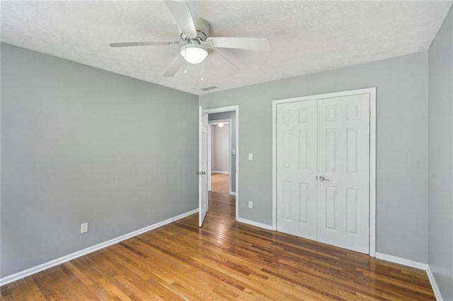 2201 Colonial Oak Way, Stone Mountain, GA 30087 - unfurnished bedroom featuring wood finished floors, baseboards, a closet, a ceiling fan, and a textured ceiling