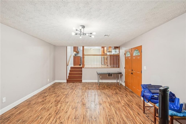 2201 Colonial Oak Way, Stone Mountain, GA 30087 - unfurnished living room with wood finished floors, stairway, baseboards, a chandelier, and a textured ceiling