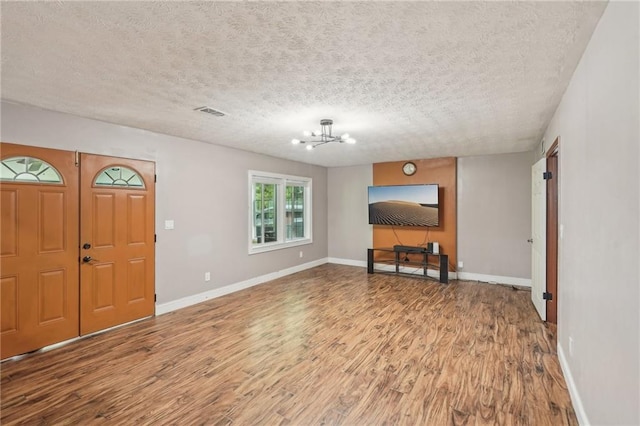 2201 Colonial Oak Way, Stone Mountain, GA 30087 - entryway with wood finished floors, a chandelier, a textured ceiling, and baseboards