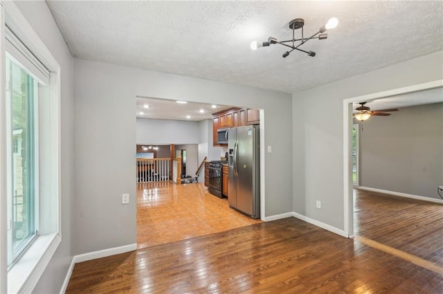 2201 Colonial Oak Way, Stone Mountain, GA 30087 - kitchen featuring appliances with stainless steel finishes, plenty of natural light, a textured ceiling, a chandelier, and light wood-style flooring
