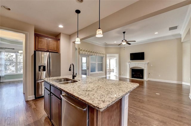 kitchen featuring hanging light fixtures, sink, dark hardwood / wood-style floors, an island with sink, and stainless steel appliances