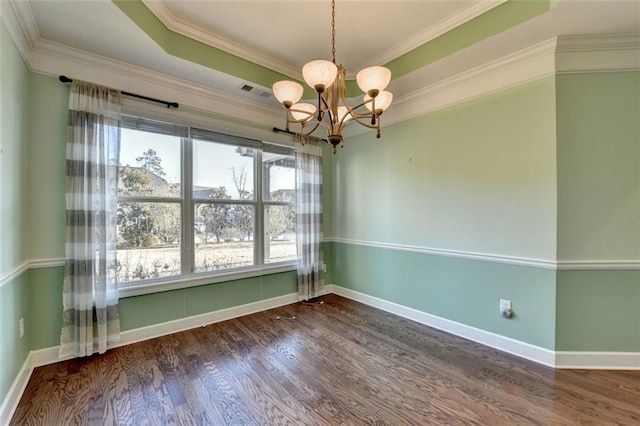 empty room featuring a chandelier, a raised ceiling, crown molding, and dark hardwood / wood-style flooring