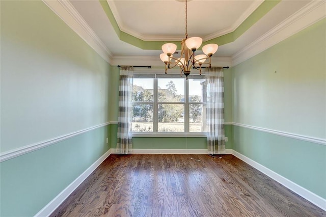 unfurnished dining area featuring a chandelier, wood finished floors, baseboards, a raised ceiling, and crown molding