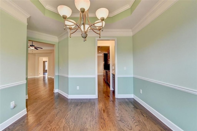 unfurnished room with ceiling fan with notable chandelier, crown molding, dark hardwood / wood-style flooring, and a tray ceiling