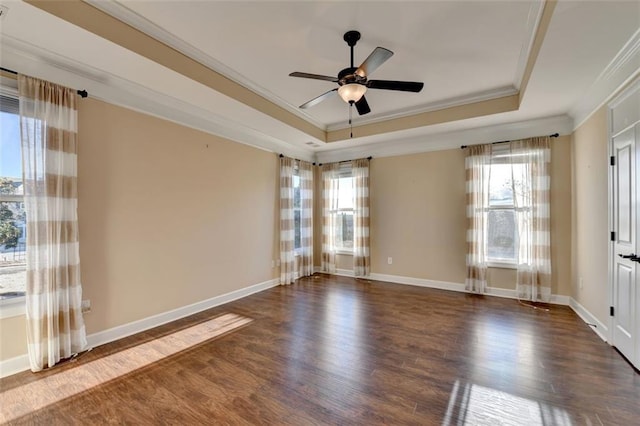 unfurnished room featuring dark wood-style floors, a tray ceiling, a ceiling fan, and ornamental molding