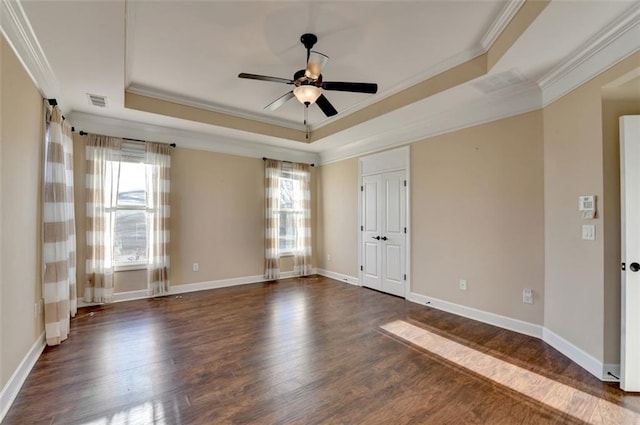 spare room with crown molding, dark hardwood / wood-style flooring, and a tray ceiling